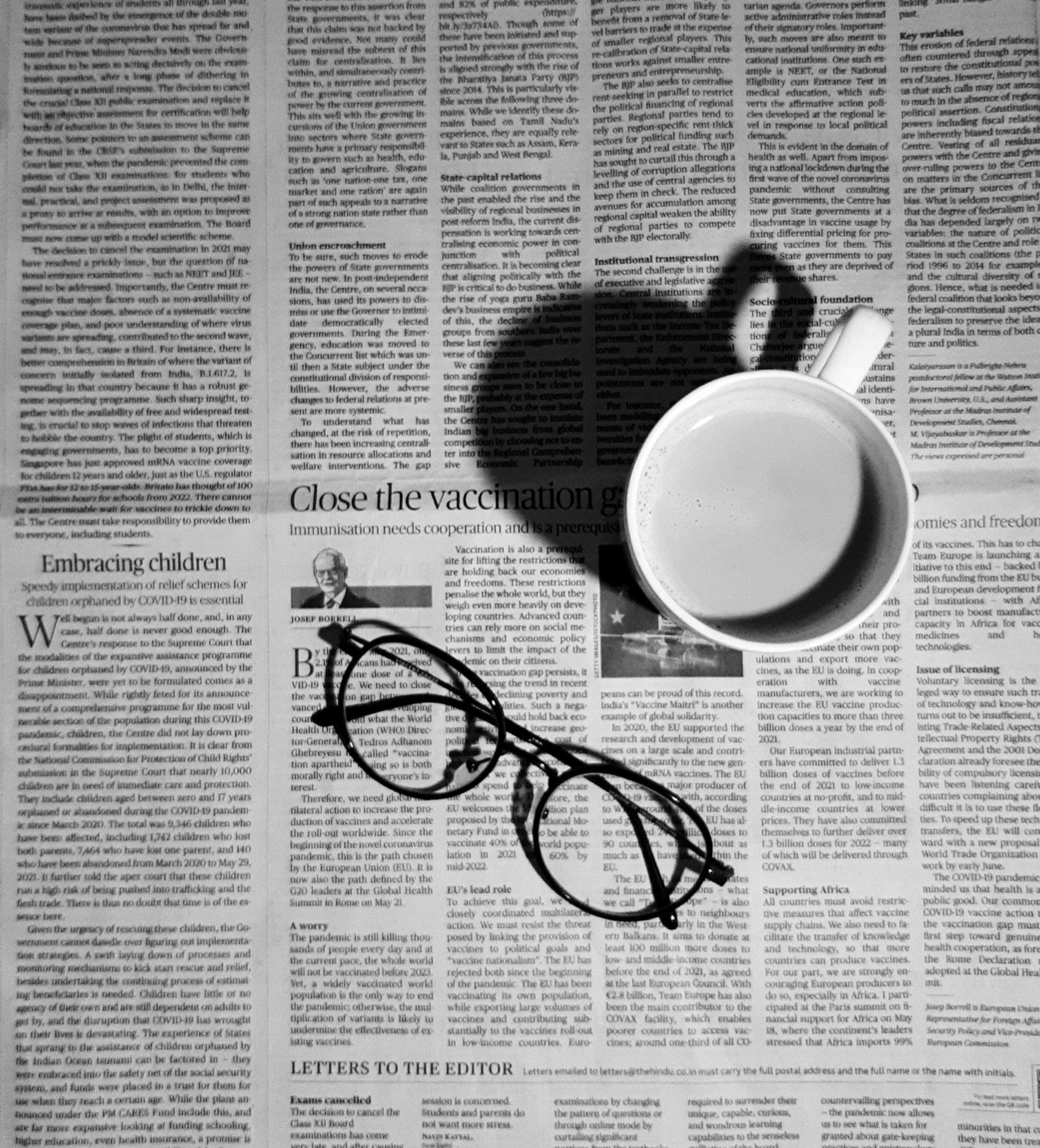 A newspaper, glasses and a coffee cup